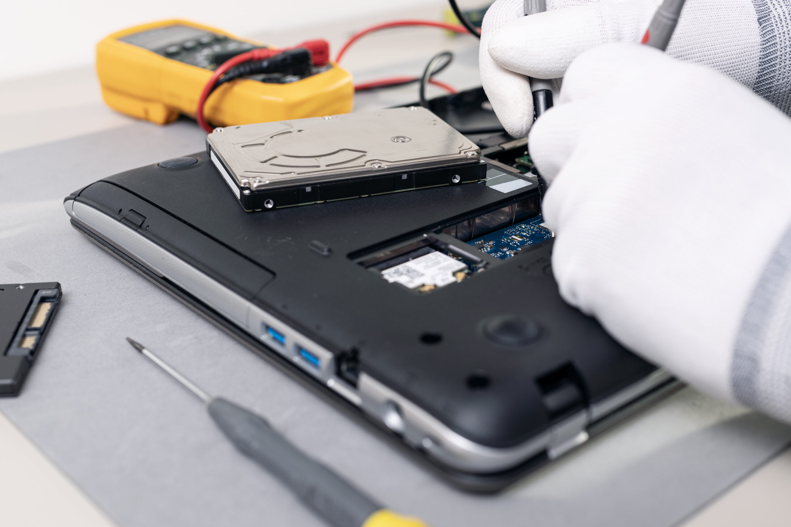 Technician hands repairing a laptop computer. Close up