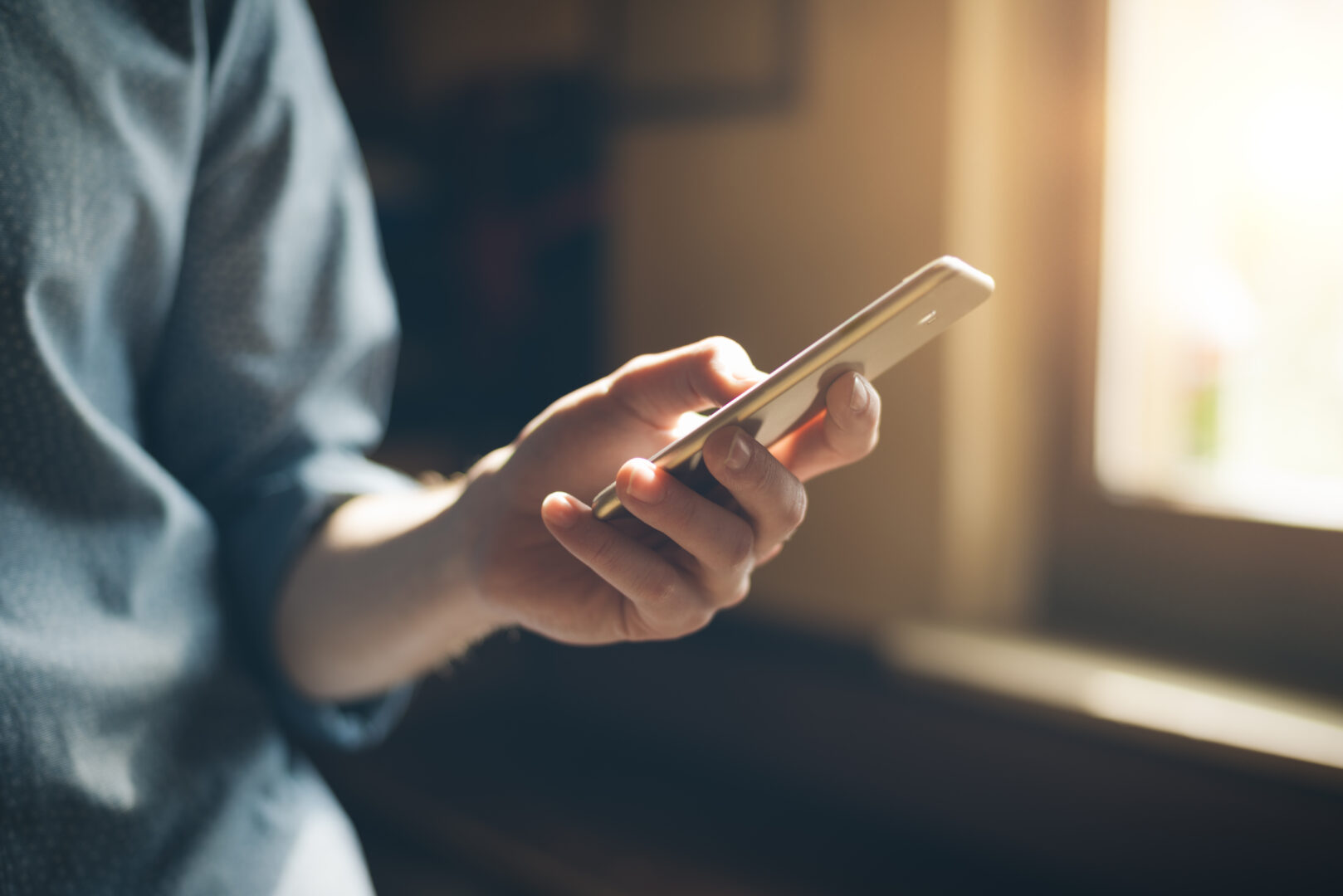 Persoon met mobiele telefoon in de hand, symbool voor zakelijke mobiele bereikbaarheid.
