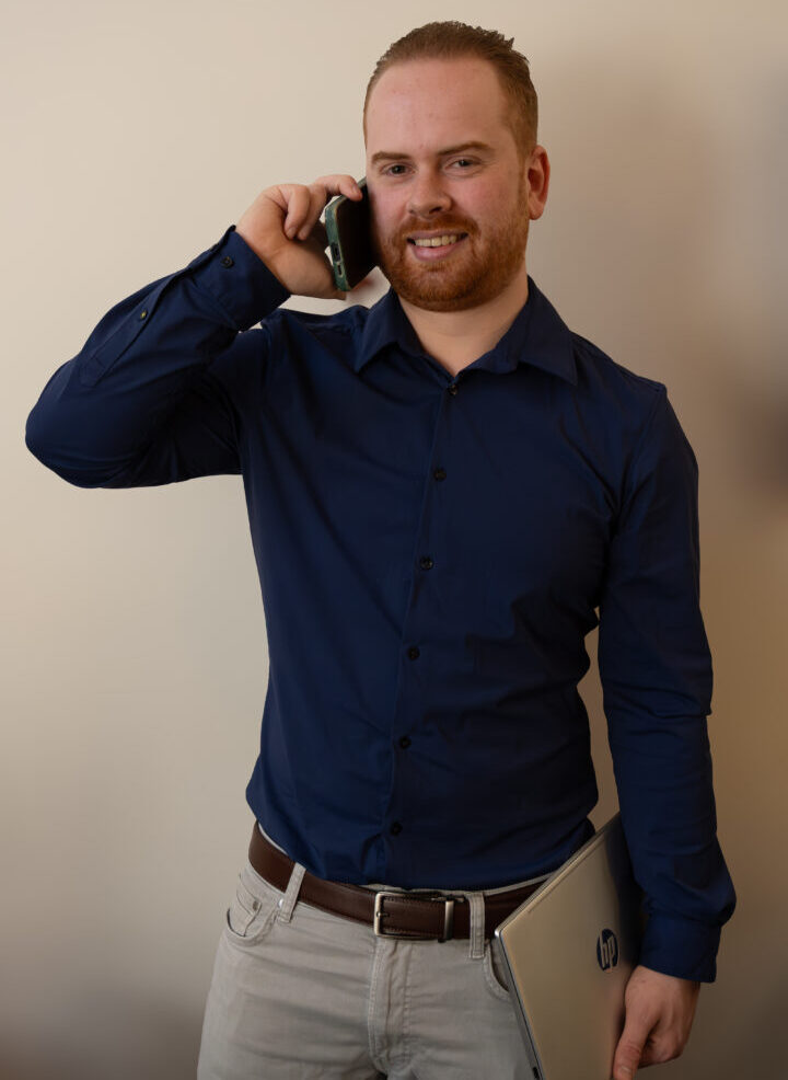 Arjan Groenendaal met telefoon aan het oor en een dichtgeklapte laptop in zijn hand.